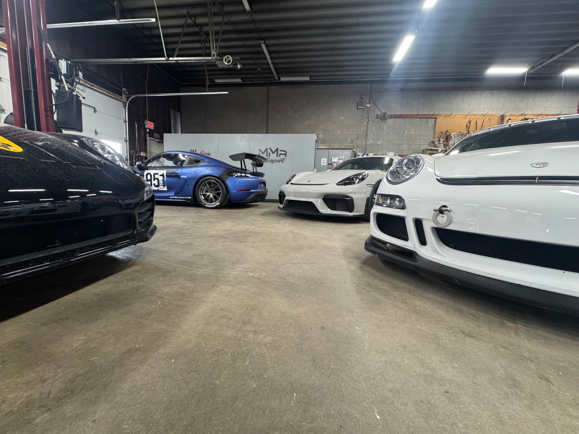 Porsches lined up inside the MMr Autosport shop bays